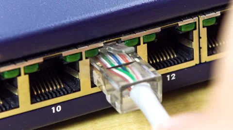 Hand plugging in network cable with lights Stock Footage 32243200