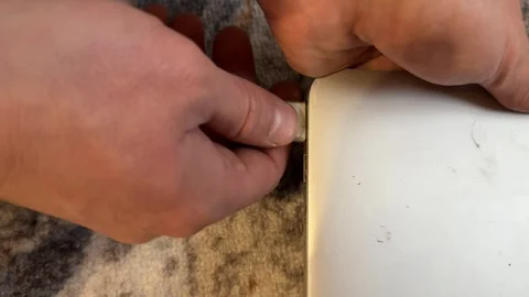 Hand plugging old charger into old laptop, charging outdated notebook computer Stock Footage 337121426