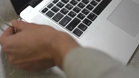 Hand plugging power adapter in laptop, everyday computer technology personal use Stock Footage 146284862