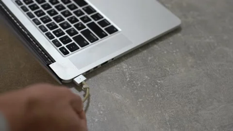 Hand plugging power adapter in laptop, everyday computer technology personal use Stock Footage 146284943