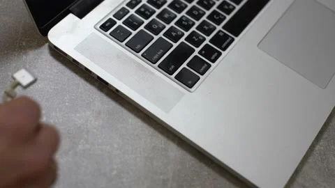Hand plugging power adapter in laptop, everyday computer technology personal use Stock Footage 146285043