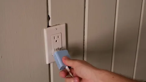 Hand Plugging Power Adapter into Wall Outlet Vídeos de archivo 337119526
