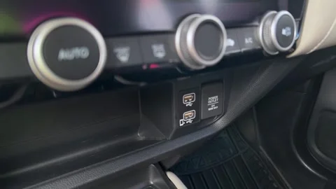 Hand plugging USB cable into car dashboard port near climate control panel Stock Footage 343710139