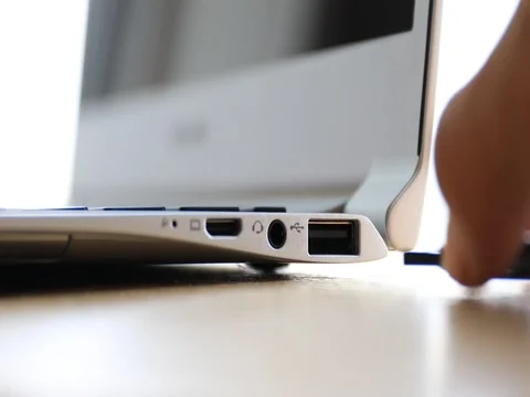 Hand plugging USB flash drive into port of laptop computer Stock Footage 81113429