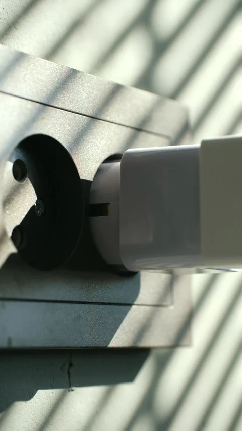 Hand plugging white power adapter into electrical socket Stock Footage 337892518