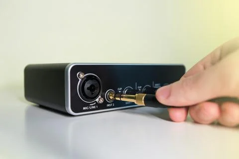 Hand plugin a headphone jack to a Sound card Stock Photos