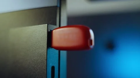 Hand plugs memory stick or flash drive device into computer at night in office Stock Footage 335241619