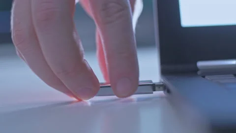 Hand plugs in USB flash drive into a laptop computer Stock Footage 143004697