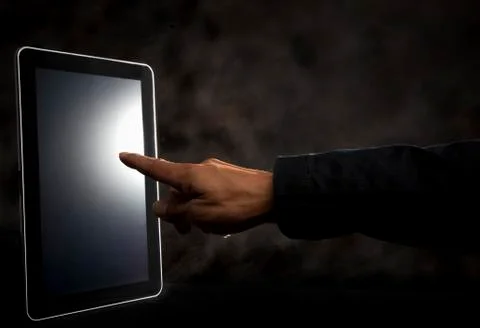 Hand point to touching on tablet screen 写真素材