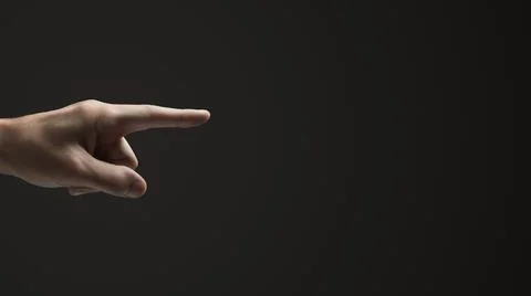 Hand pointer. Dark background. Copy space. Stock Photos