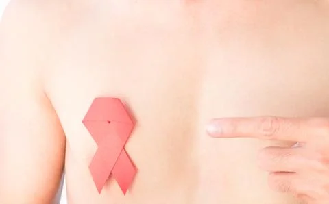 Hand pointer finger to red ribbon on chest for AIDs awareness concept Stock Photos