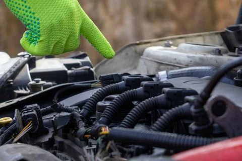 Hand Pointing at Car Ignition Coil Engine Parts During Maintenance Work in .. Stock Photos