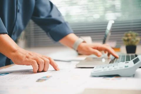 Hand pointing to financial chart while using calculator and laptop on a bri.. Stock Photos