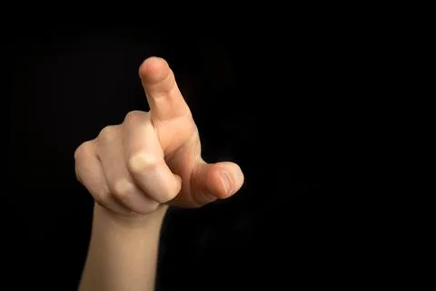 Hand pointing gesture on empty space on a black background Foto stock