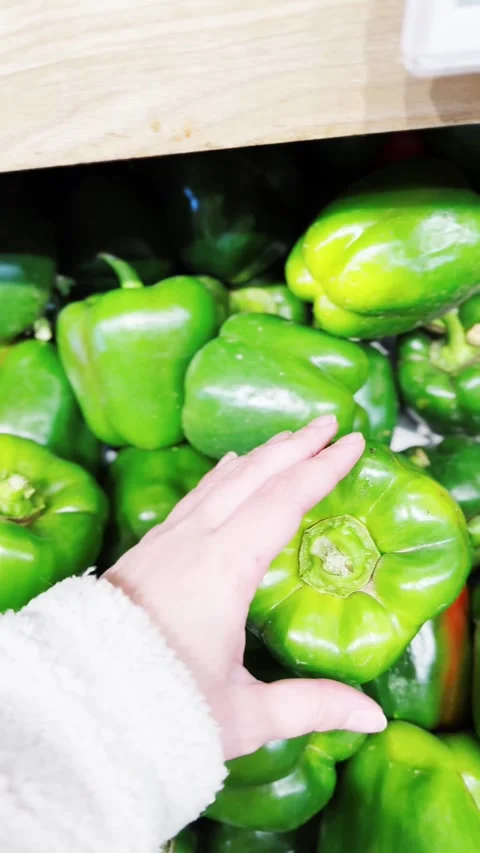 A hand is pointing at a green pepper Stock Footage 325140065