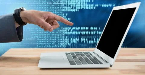 Hand pointing at laptop with coding text 写真素材