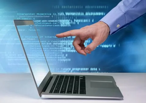 Hand pointing at laptop with coding text Stock Photos