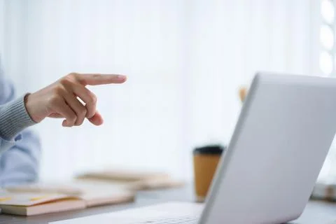 Hand pointing at laptop screen during online education lesson in bright mod.. Stock Photos