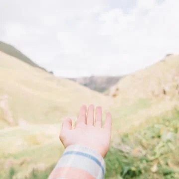 Hand pointing at mountain valley. Stock Photos