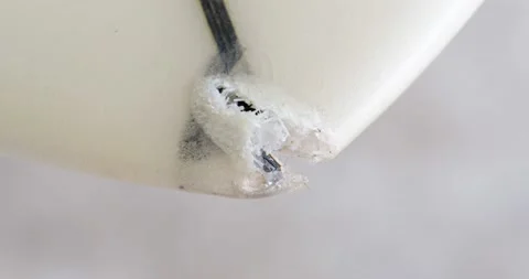 Hand pointing out the damaged part on nose to repair on a surfboard. Stock Footage 239484708