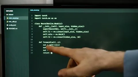 Hand pointing at programming code on computer screen. Stockfoto's