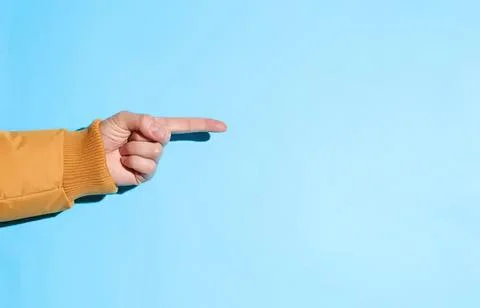 Hand pointing to the right on a blue background Stock Photos