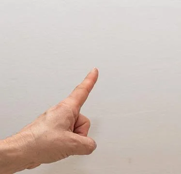 Hand pointing right with space for text on plain background Stock Photos