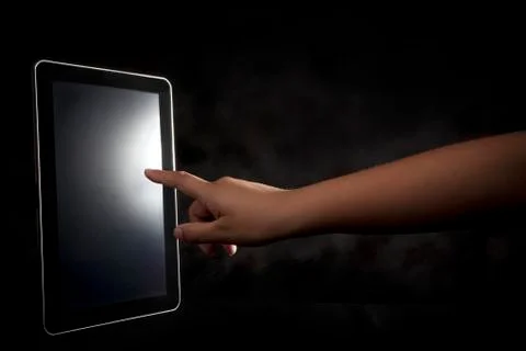 Hand pointing to tablet on dark background 写真素材