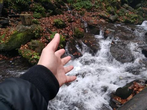 Hand pointing at the waterfall. Stock Photos