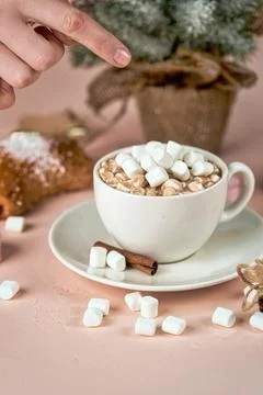 Hand points to a cup of coffee with marshmallows Foto stock