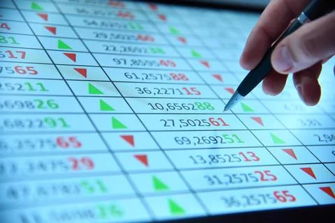 Hand points to financial statistic on computer screen. Stock Photos