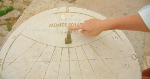A hand points at markings on a marble sundial engraved with Monte Solaro in Stock Footage 345688115