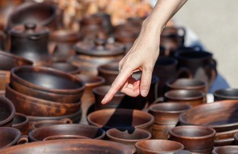 A hand points to a pot on a table Stock Photos
