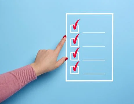 A hand points to a white outline list with red checkmarks and a blue backgr.. Stock Photos