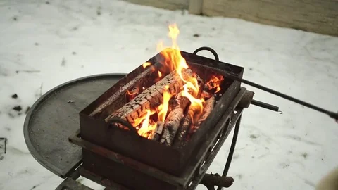 Hand with poker adjusts the coals in the brazier Stock Footage 70933004