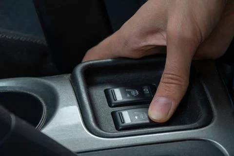Hand positioned over car control buttons for air conditioning and defrosting  Stock Photos