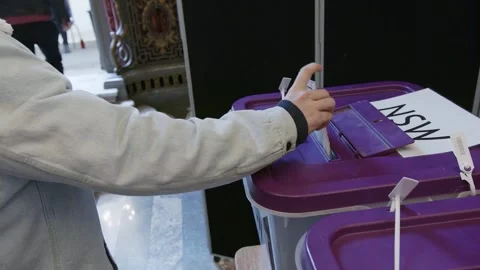 A hand posts a ballot paper into the NSW ballot box Stock Footage 345299106
