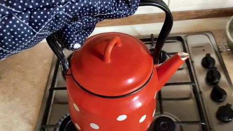 Hand with Potholder Taking Old Red Teapot. Glasses on Old Fashioned Kitchen Stock Footage 251944721