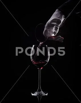 Hand pour red wine from decanter to glass Stock Photos