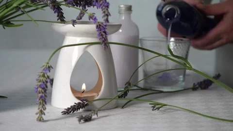 Hand pouring bubble bath with fresh lavender flowers for aromatherapy Stock Footage 317993036