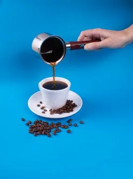 Hand pouring coffee into a cup from a vessel Stock Photos