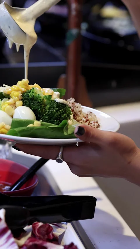 Hand Pouring Creamy Dressing Over Fresh Salad Bar Plate Stock Footage 323414381