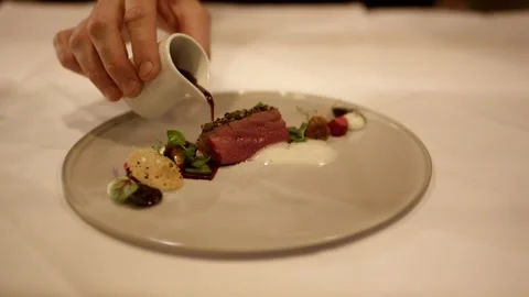 Hand Pouring Dark Sauce from Small Jug onto Plated Main Course, Close Up Shot Vídeo Stock 341345907