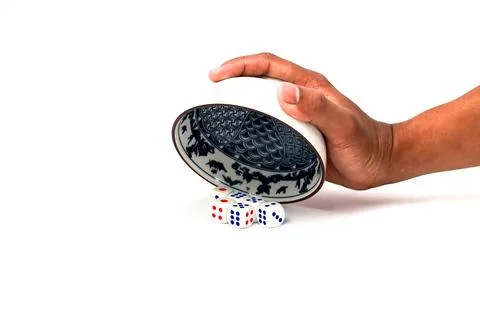 Hand Pouring Dice From Blue Patterned Bowl On White Background Stock Photos
