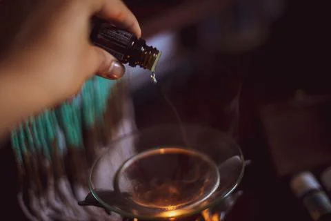 Hand pouring essential oil on diffuser Stock Photos