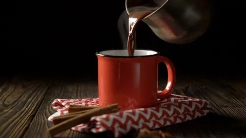 Hand pouring hot chocolate into the red cup Stock Footage 122764759