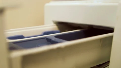 Hand pouring liquid detergent or softener into the washine machine dispenser Видео 107983984