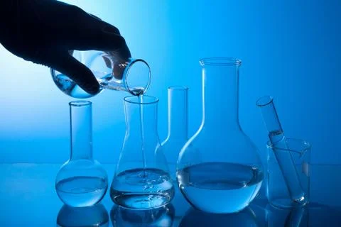 Hand pouring liquid into flask Stock Photos