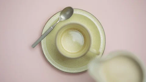 Hand pouring milk into cup Stock Footage 94884906