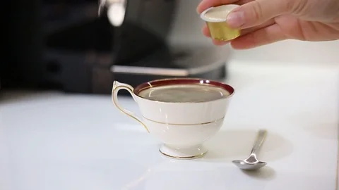 Hand pouring milk into a cup of fresh espresso coffee Video stock 107742756